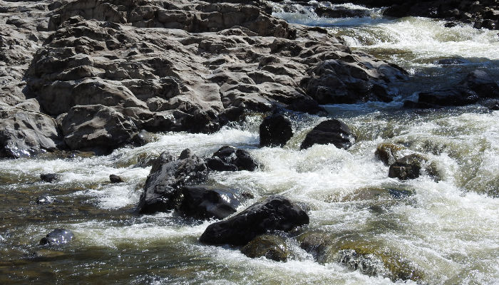 Wasser des Flusses fliesst über Steine im Fluss der jungen Emme