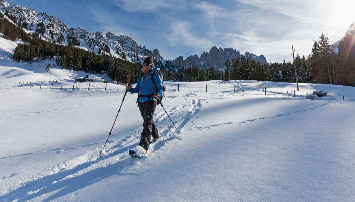 Schneeschuhwanderin in verschneiter Landschaft in den Bergen