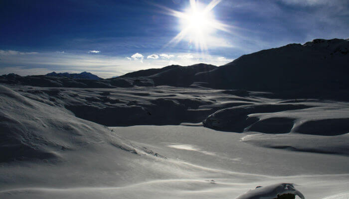 Schneebedeckter Grimselpass bei sonnigem Wetter im Winter