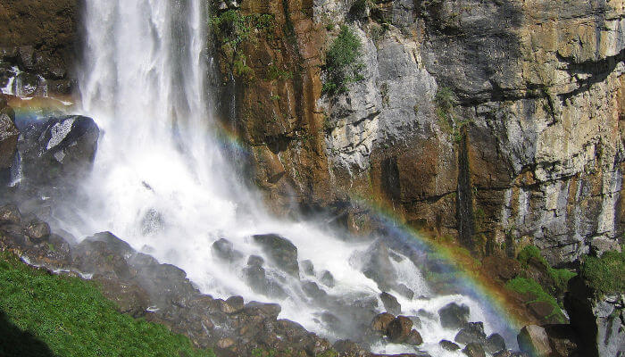 Wasserfall in den Bergen fällt auf Felsen im Sommer