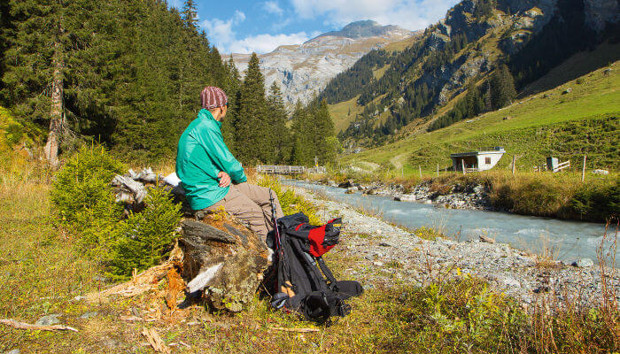 Wanderer mit Rucksack am Fluss im Sommer