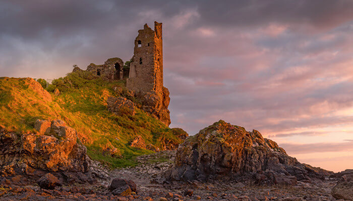 Schlossruine an einer Küste in der Abendsonne