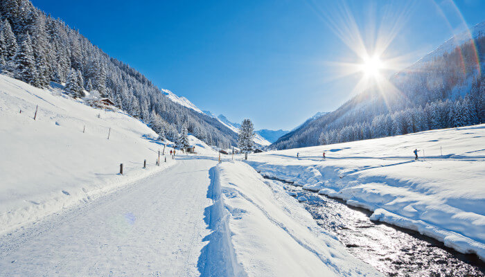 Fluss an Wanderweg im Winter bei Sonnenschein