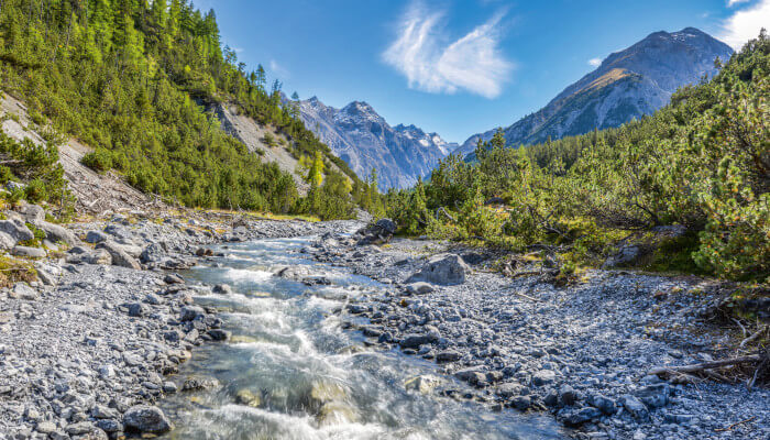 Fluss durch Steinbeet im Tal im Frühling