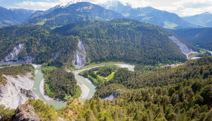 Blick in ein Tal mit Fluss und grünen Tannen und Bäumen