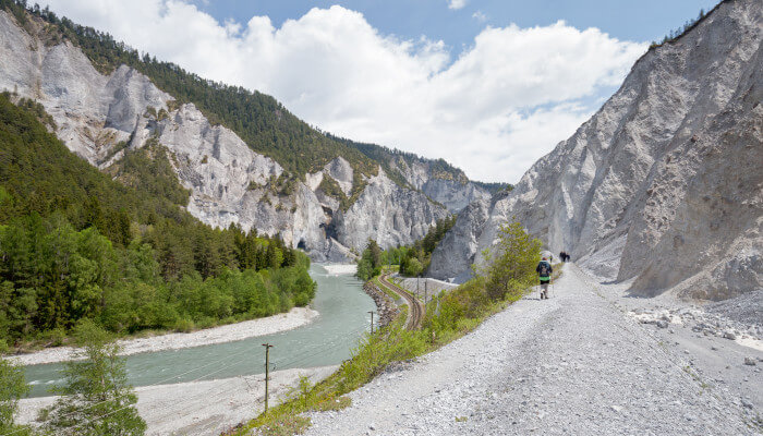 Kiesweg neben Fluss in einem Tal