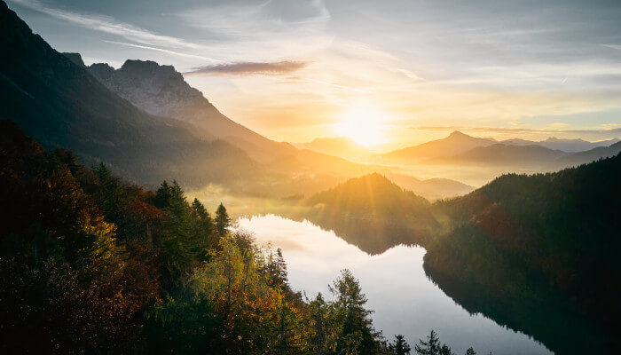 Sonnenuntergang vor einem Bergsee im Herbst