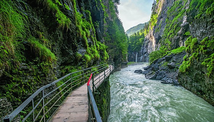 Steg durch eine Schlucht mit Fluss im Frühling